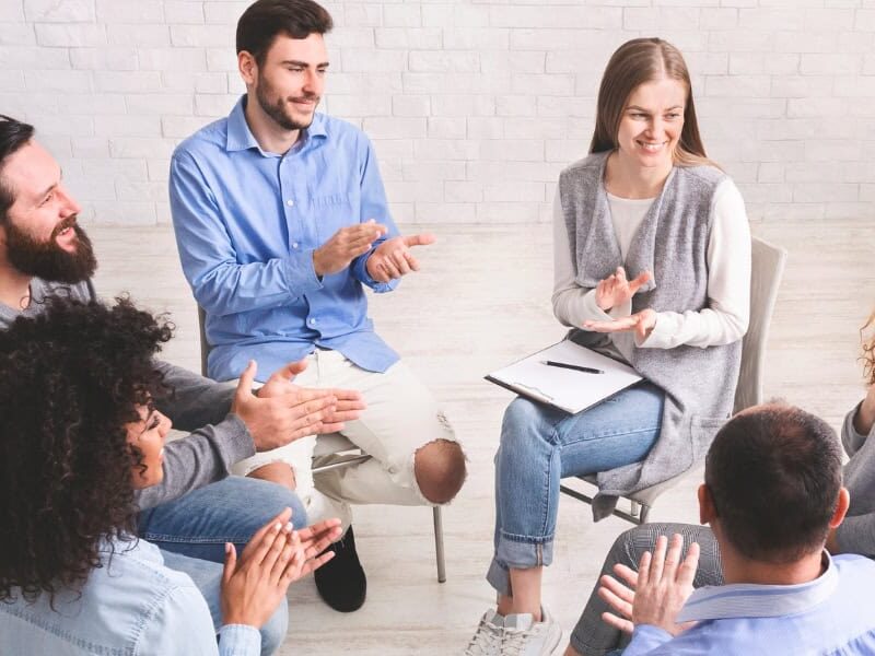 Family members sitting together in a supportive conversation representing the guidance Izzy's House provides to Ohio families choosing a sober living home